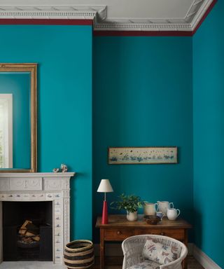 living room with teal walls, white fireplace and traditional decor