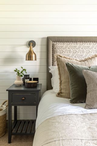 A neutral scheme with wall lamp showing how to make a small bedroom look bigger.
