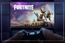 With Playstation controller in hand, a man prepares to play Fortnite: Save the World as the intro loading screen in seen on a TV