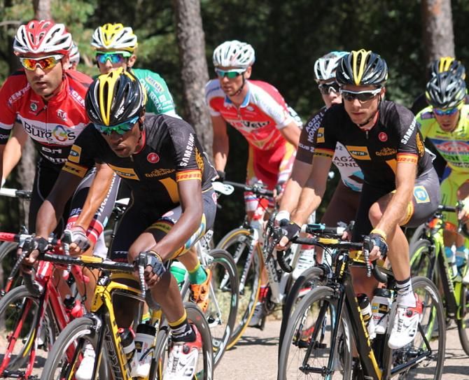 Adrien Niyonshuti guides Jacques Janse van Rensburg in the peloton