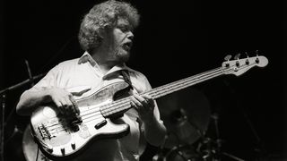 Donald 'Duck' Dunn performs on stage with Eric Clapton at Ahoy, Rotterdam, Netherlands, 23rd April 1983. He plays a Fender Precision bass guitar.