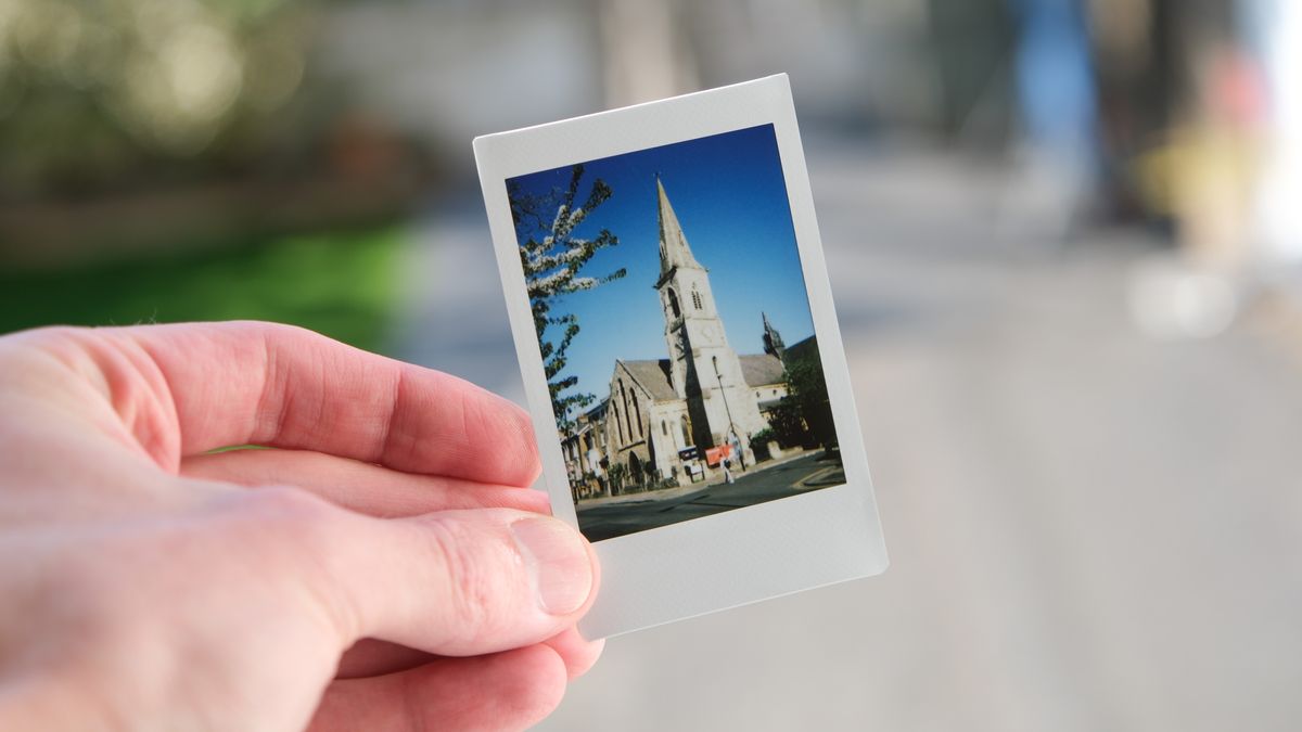Fujifilm Instax Mini print of a church held in a hand