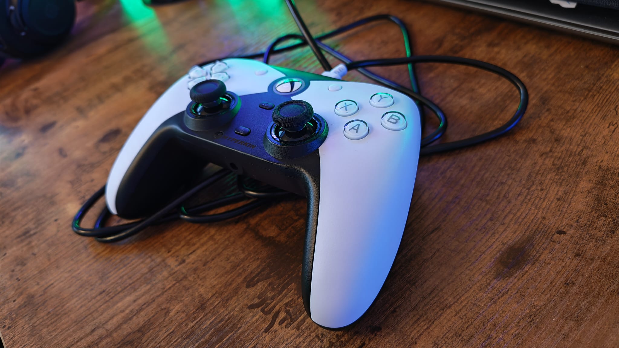 A Hyperkin Competitor sitting on its cable on top of a gaming desk