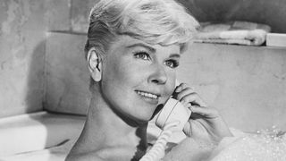 Doris Day smiles on the phone in a bathtub in Pillow Talk