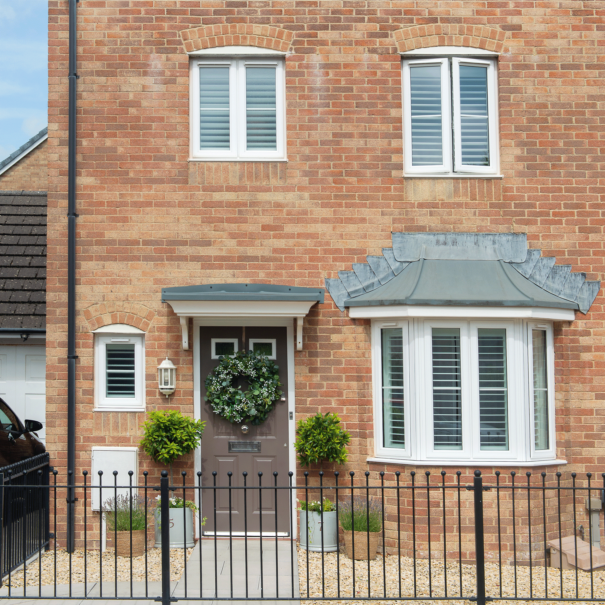 the exterior of a house with a front door and iron fencing