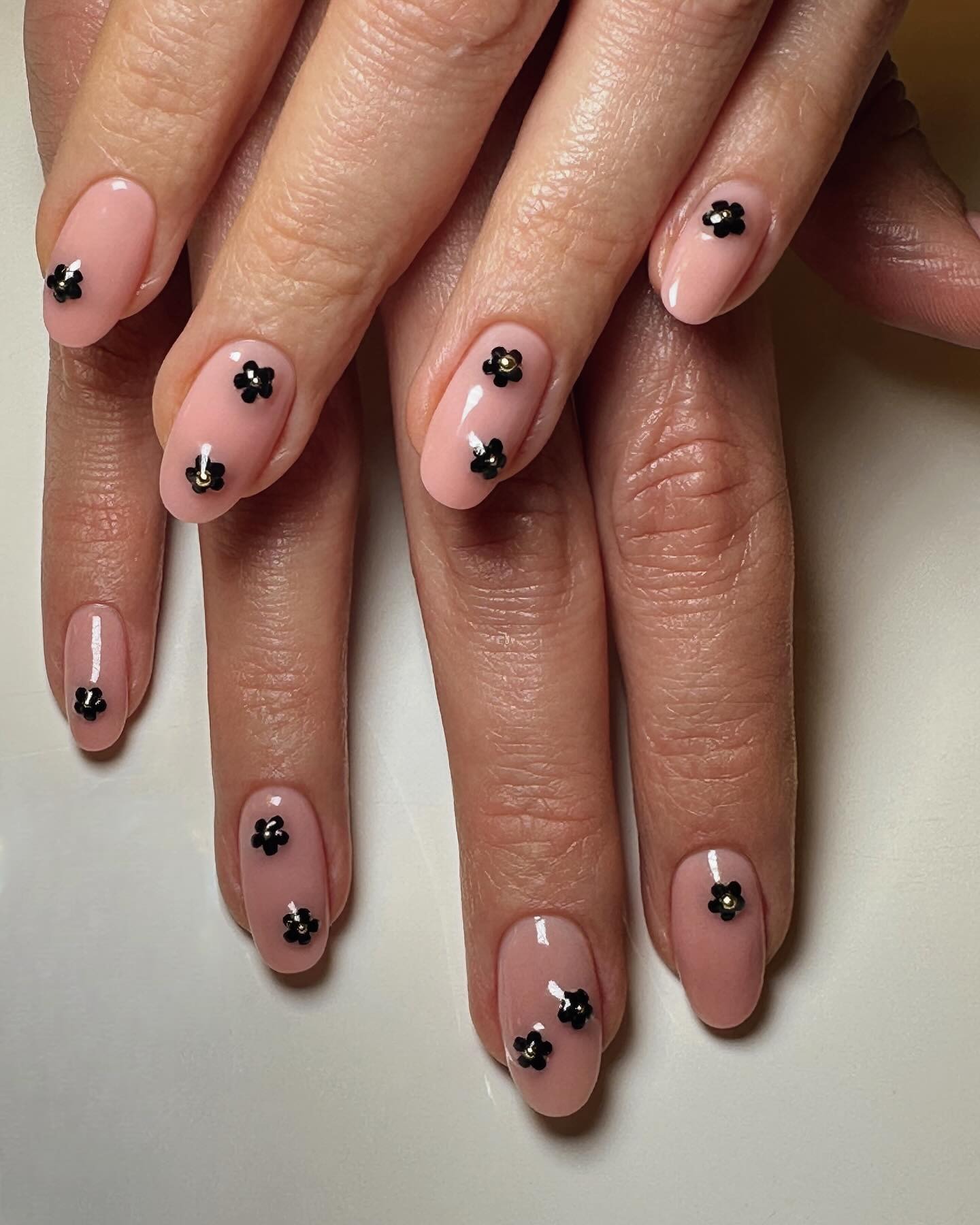 Nude nails with black daisies