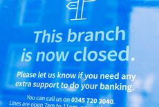 Sign displayed in closed Barclays bank branch which reads: "This branch is now closed. Please let us know if you need any extra support to do your banking."