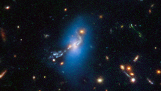 The Hubble Space Telescope has imaged a glowing phenomenon called intracluster light, which is light emitted by wandering stars, which are not gravitationally bound to others. The blue color is artificially added for emphasis.