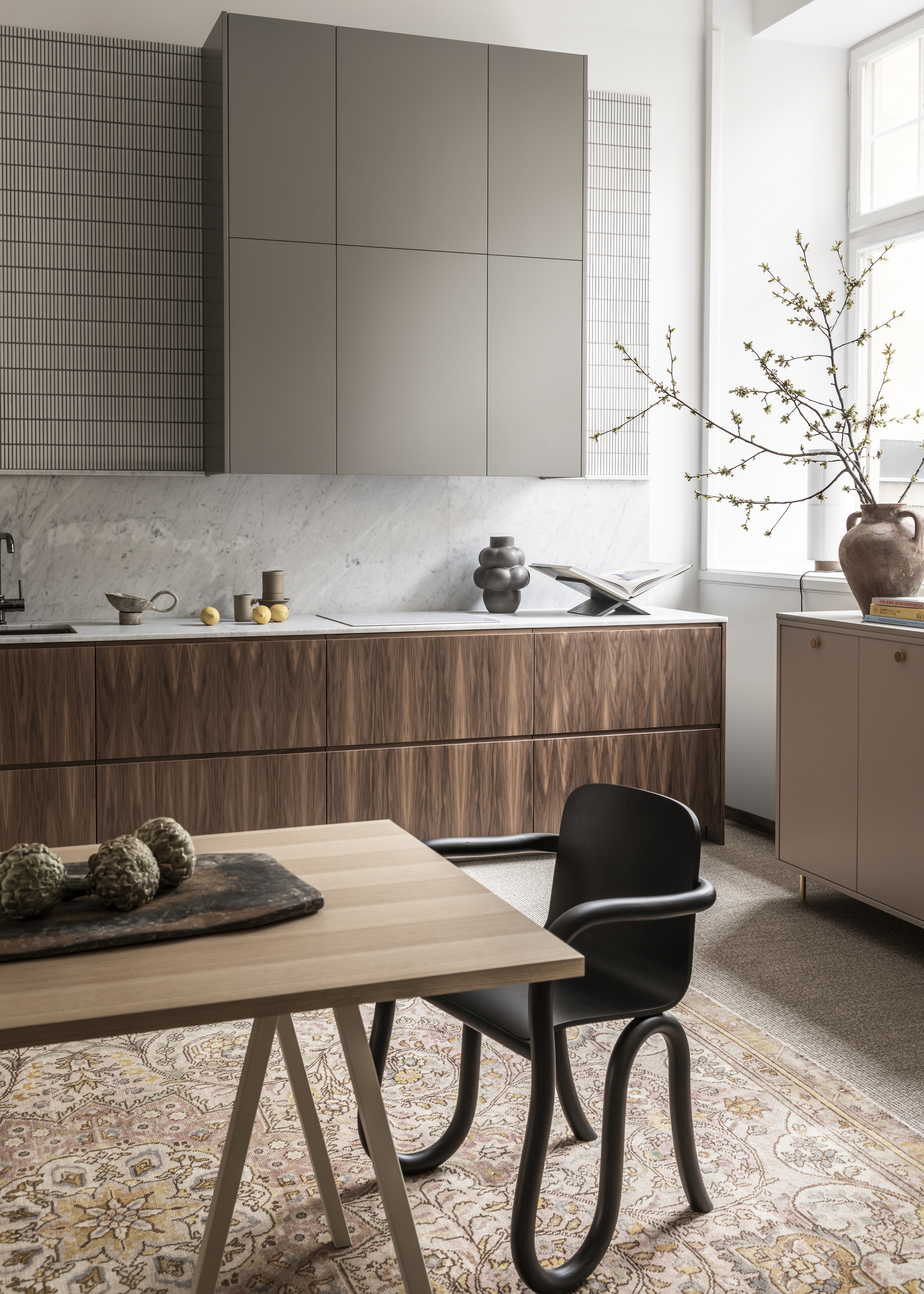 A modern kitchen with wooden effect lower units and grey slab upper units