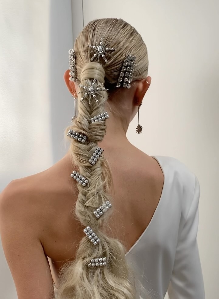A model wears a slicked-back and textured fishtail braid with Lelet NY hair barrettes