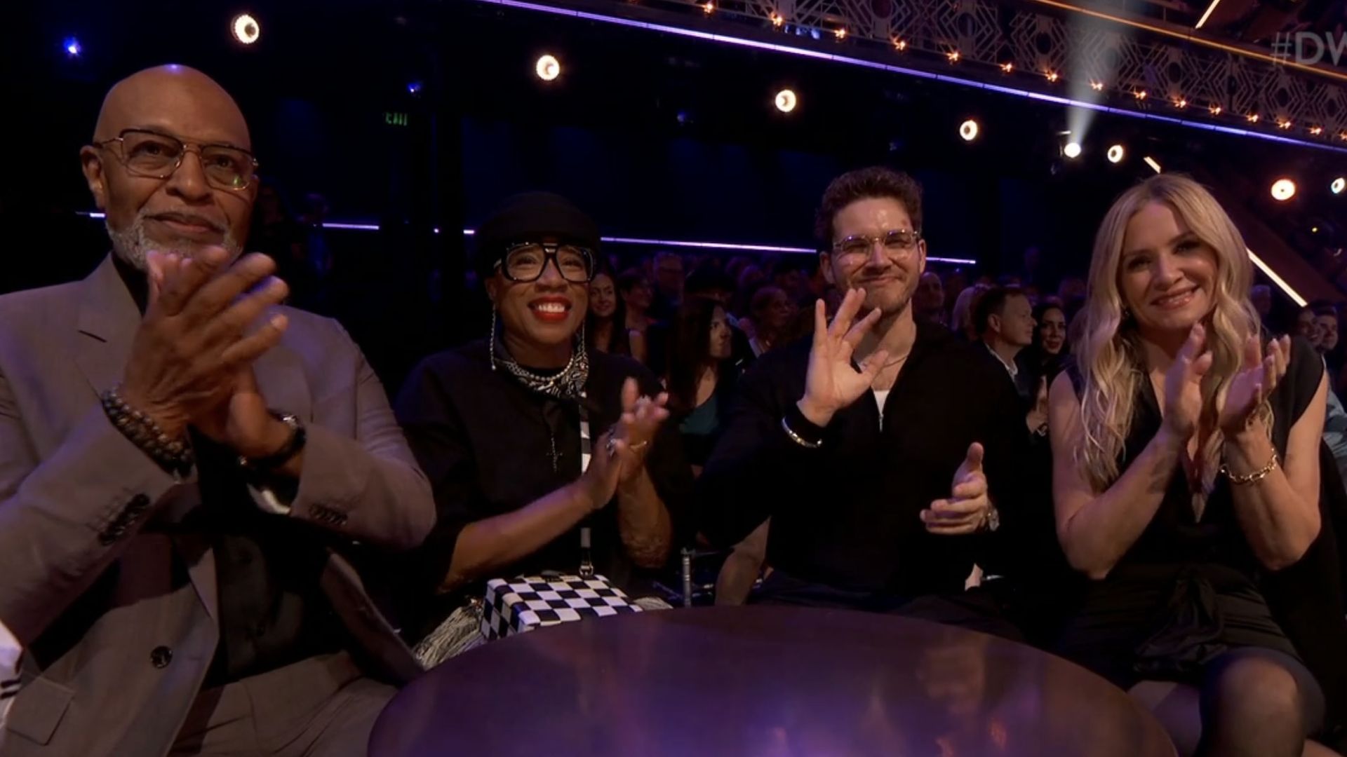 James Pinkens Jr. and Jessica Capshaw smiling at a table on DWTS.