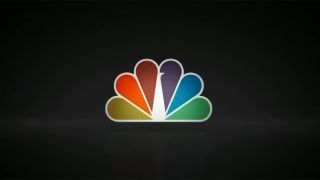 A look at the Peacock logo from a few years ago in an NBC ad. The peacock is rainbow-colored and background is black.