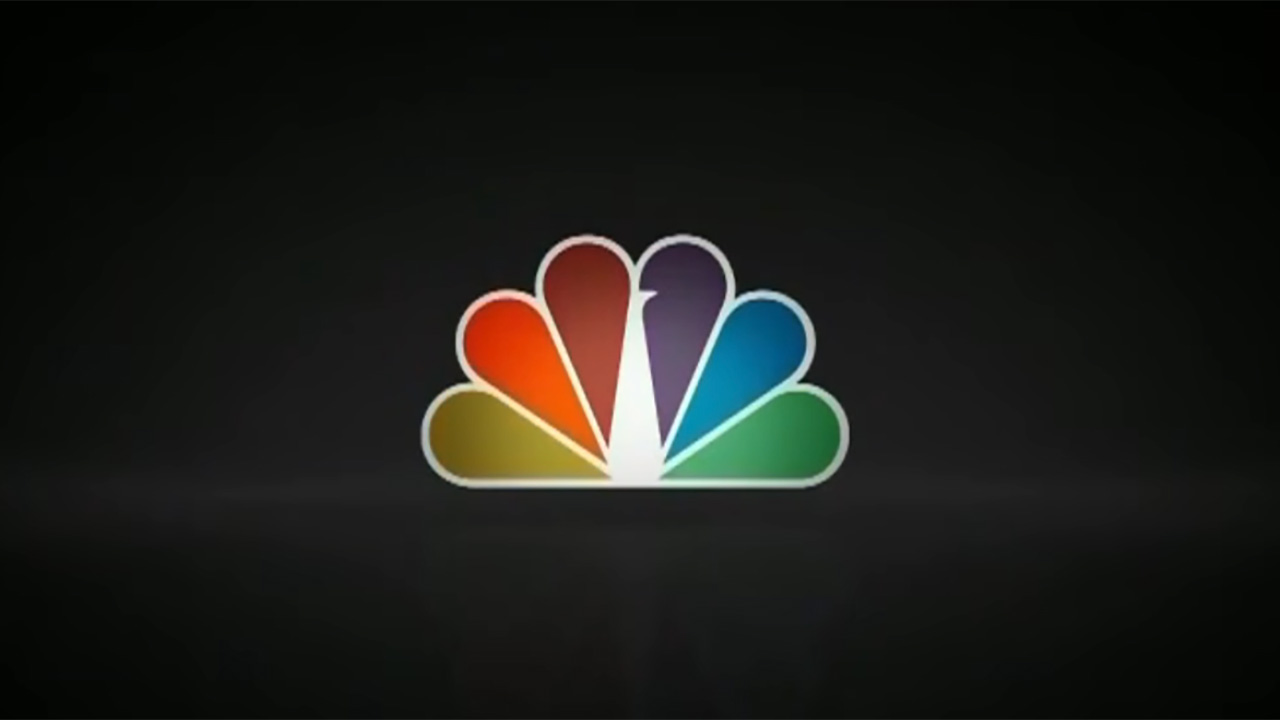 A look at the Peacock logo from a few years ago in an NBC ad. The peacock is rainbow-colored and background is black.