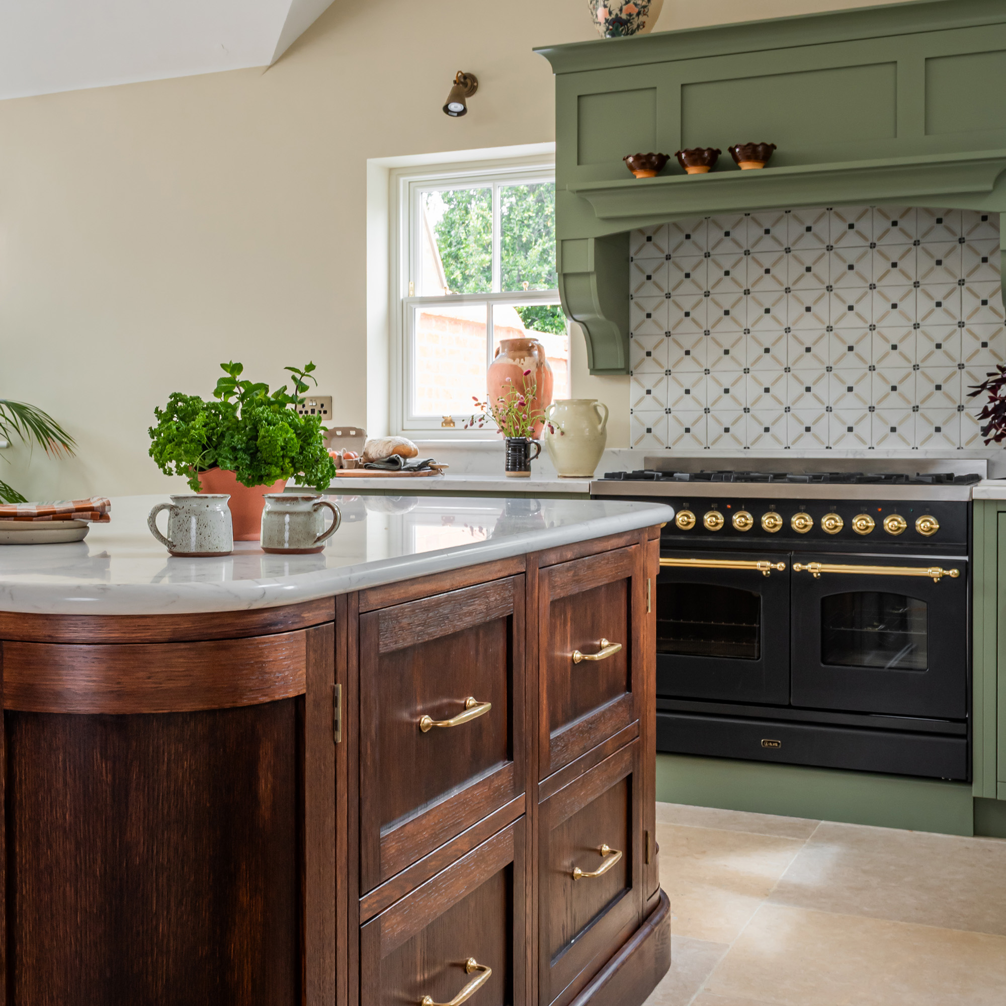 kitchen with cream wall green cabinetry and wooden curved kitchen island black oven with patterned splashback