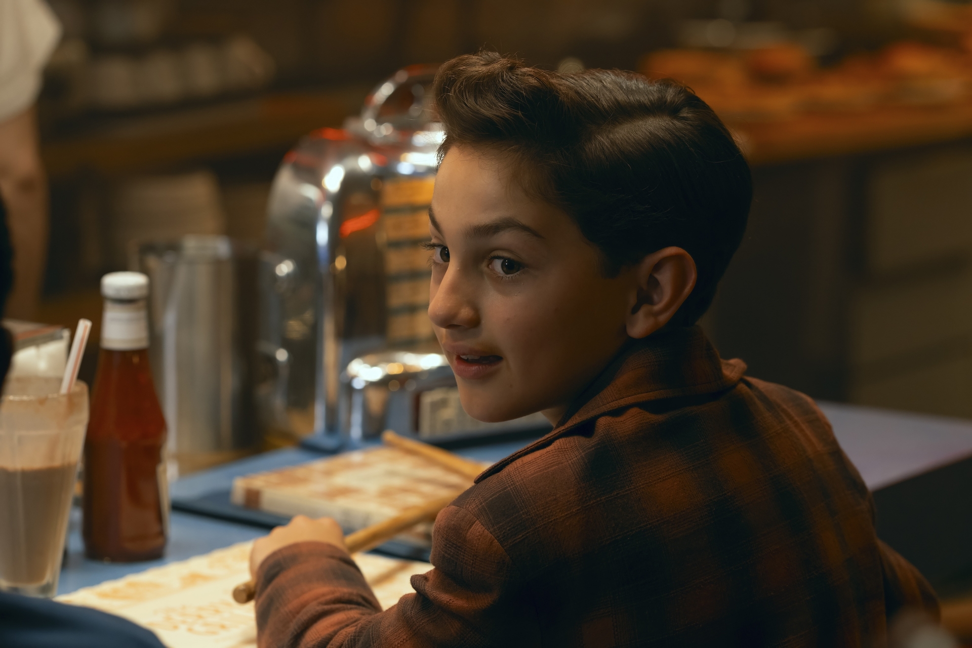 arian s cartaya as rich sitting at a diner counter in a still from it welcome to derry