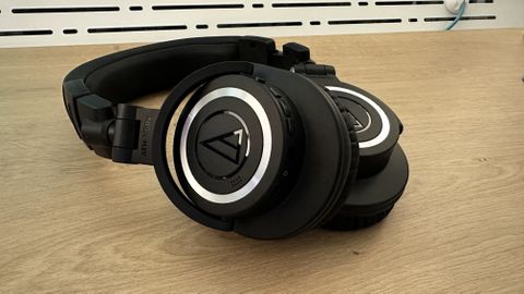 Audio Technica ATH-M50xBT2 headphones on a wooden surface