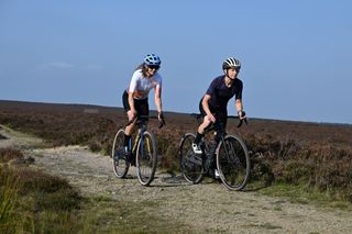 Two cyclists riding gravel bikes on a UK trail