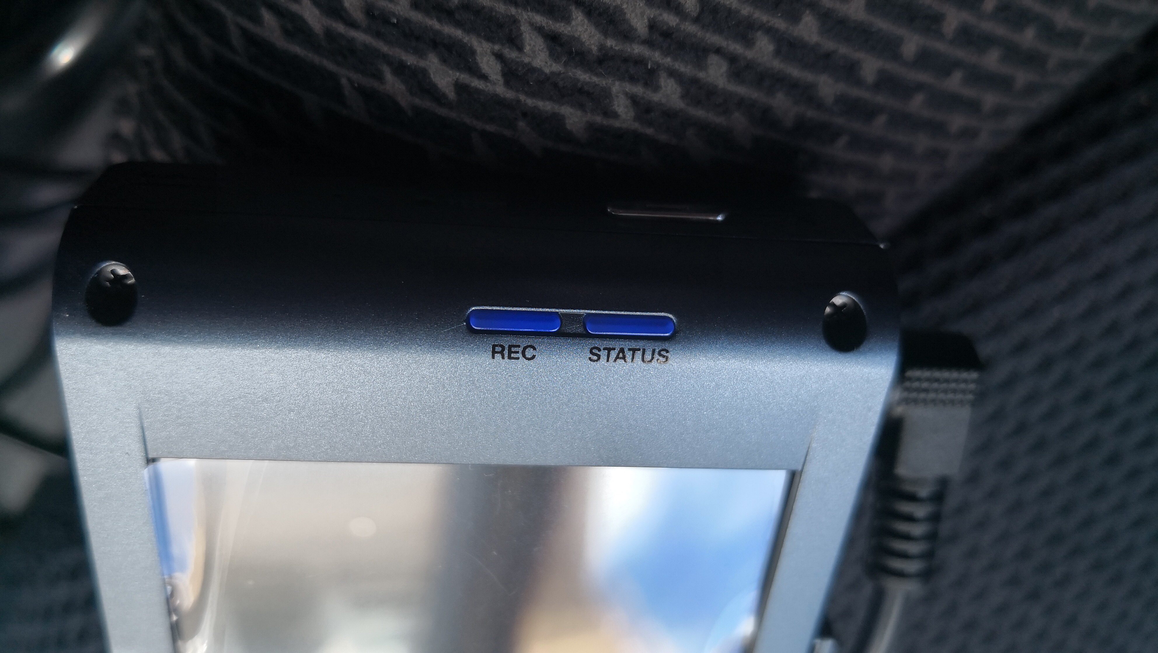 The Thinkware X1000 dash cam sitting on a car seat