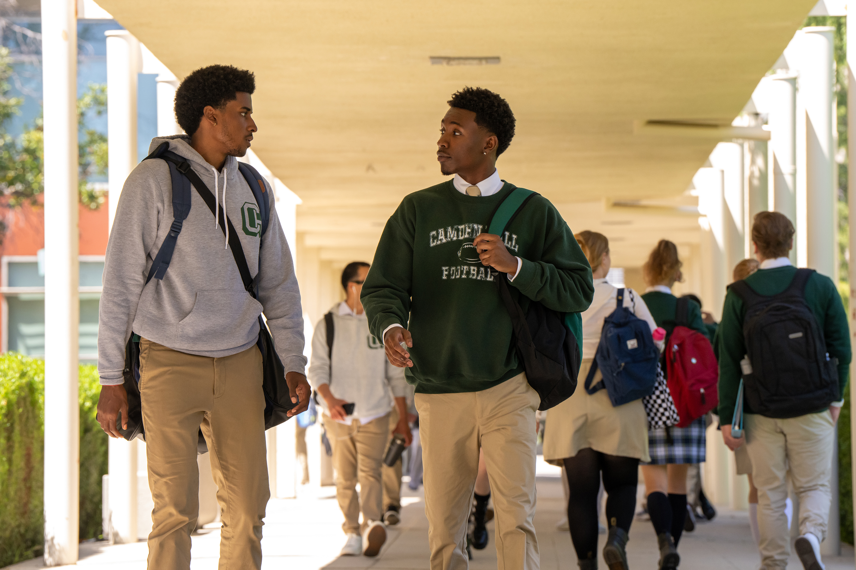 Michael Cooper Jr. as Justin Edwards and Niles Fitch as Darius walking in the hallway of school in the tv show forever