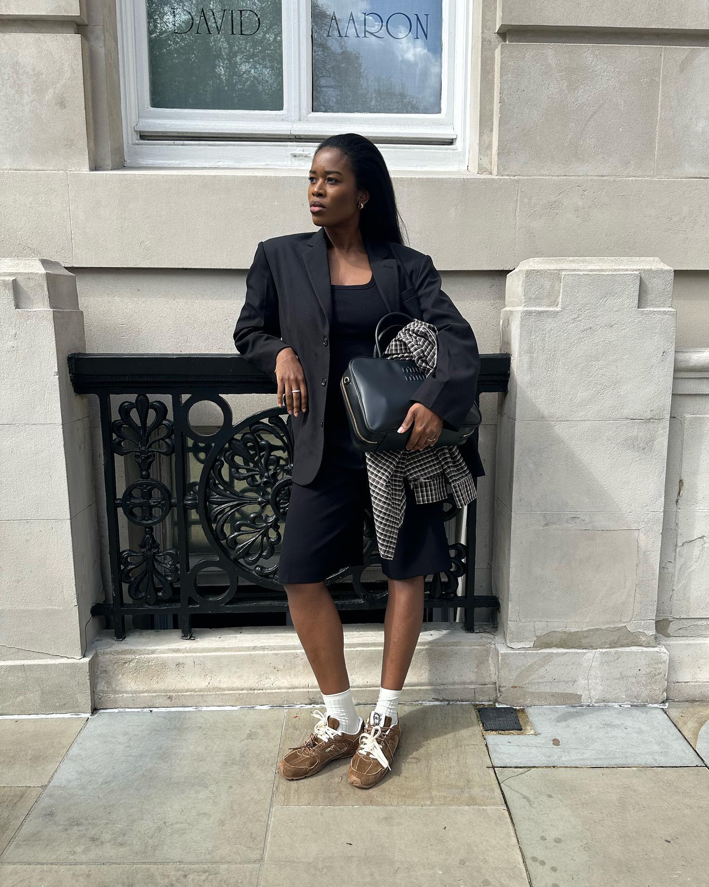 @nlmarilyn wears a pair of suede trainers with black cropped trousers and a black blazer