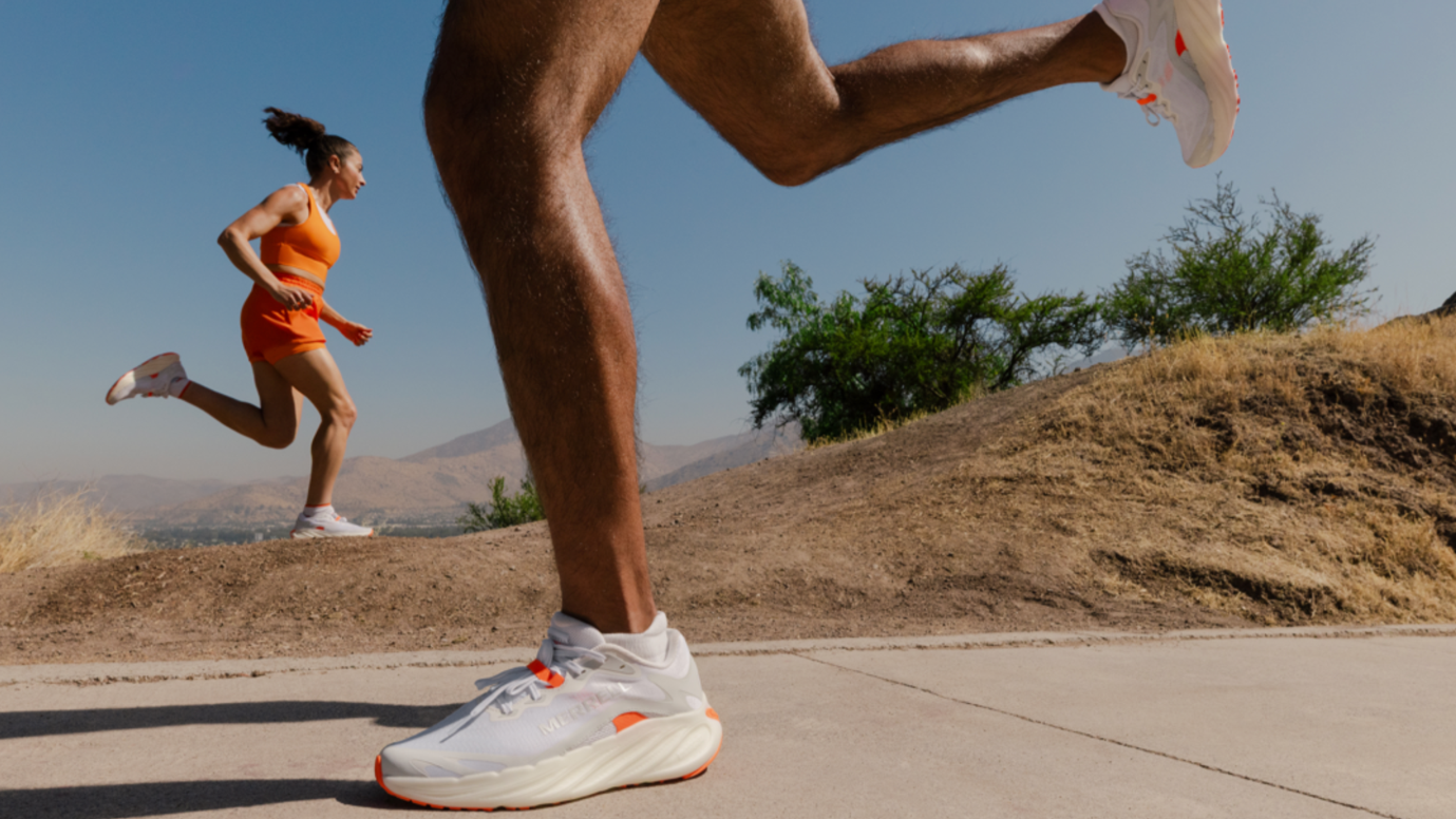 Press image showing one runner wearing the Merrell ProMorph on the road and another wearing it on the trail