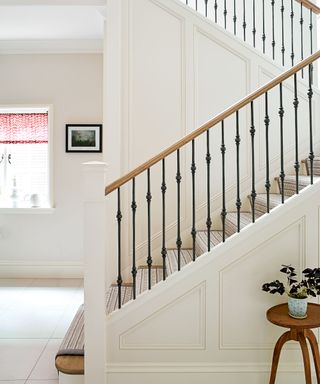 White entryway with wall panels and tiled floor
