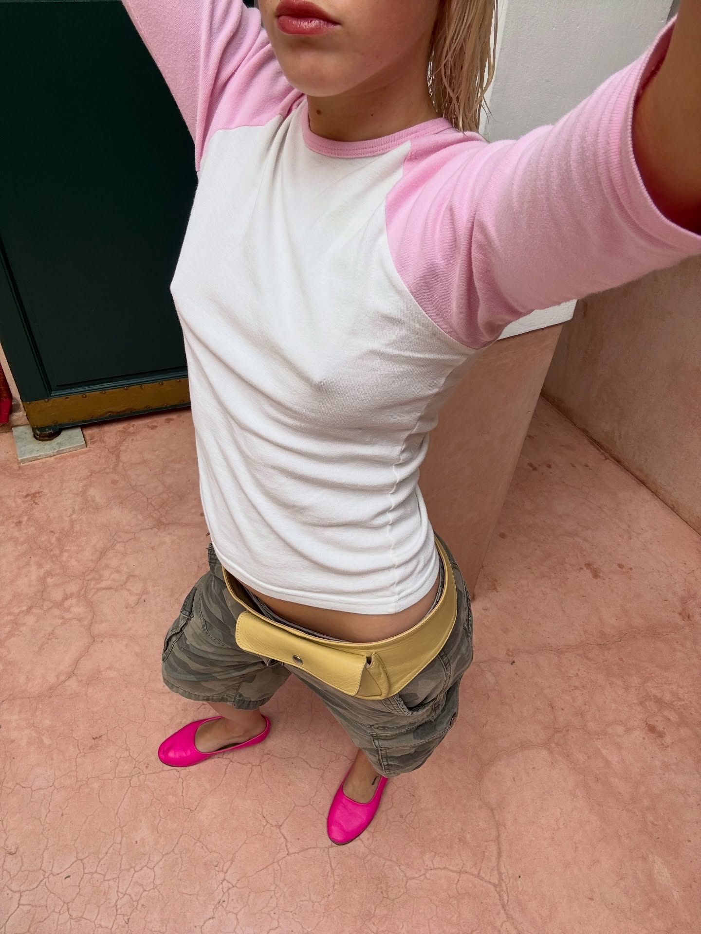 An image of @elsiematilda wearing a pink-and-white raglan T-shirt with camo-print khaki trousers and hot pink ballet flats.