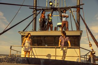 Madelyn Cline as Sarah Cameron, Carlacia Grant as Cleo, Madison Bailey as Kiara, Chase Stokes as John B, and Jonathan Daviss as Pope, standing on a boat, in episode 409 of Outer Banks.