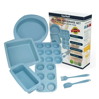 a light pastel blue seven piece set of different silicone bakeware sat together next to their product box including two muffin trays, spatulas and round oven trays