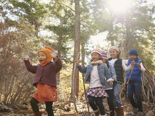 A group of happy children hike through the woods