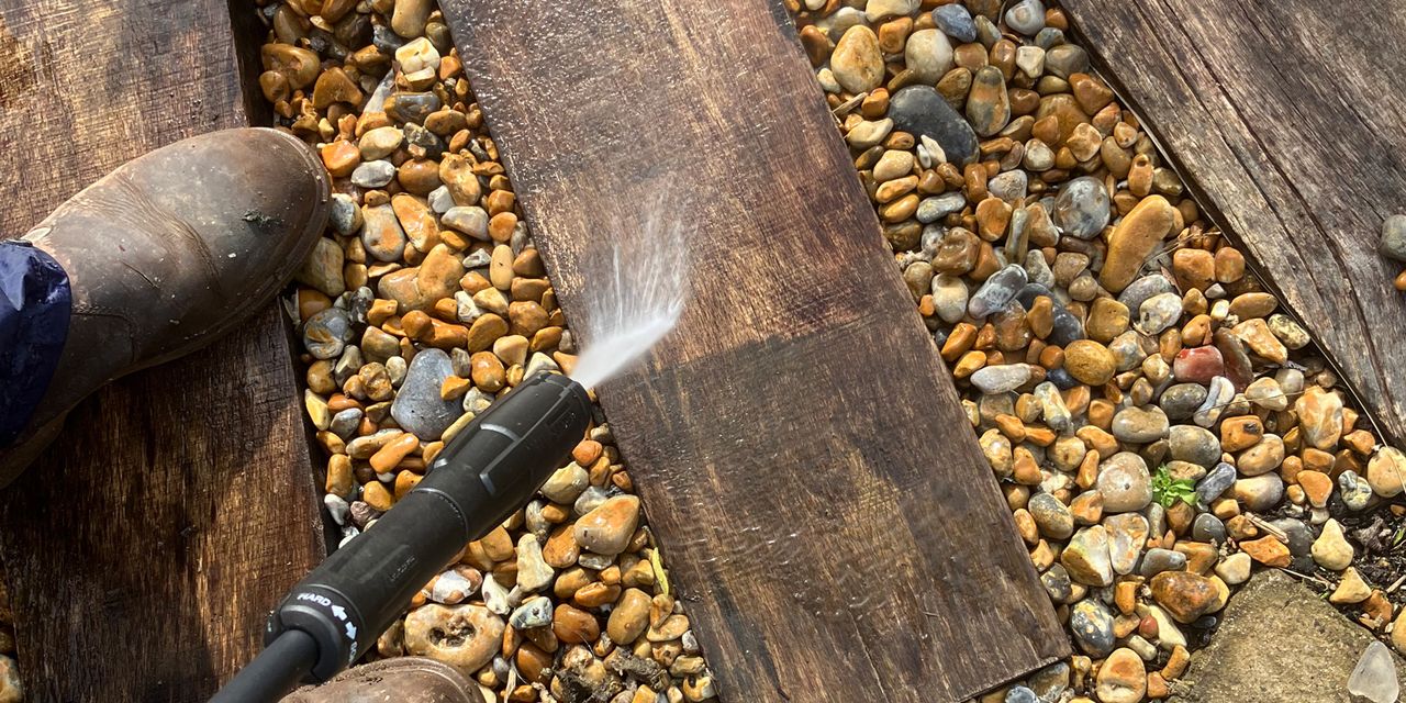 Pressure washer being tested on wood in garden 