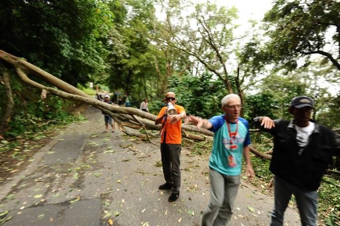 Tour de Singkarak 2013 officers set the riders to avoid a fallen tree blocking the road in Kelok 44 Hill