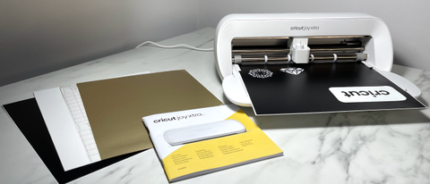 Cricut Joy Xtra review; a small white craft machine on a marble table with card materials