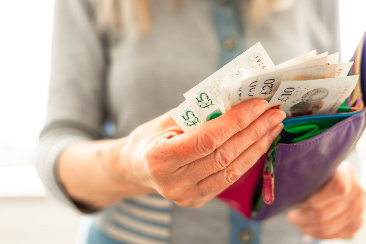 Woman taking bank notes out of her wallet