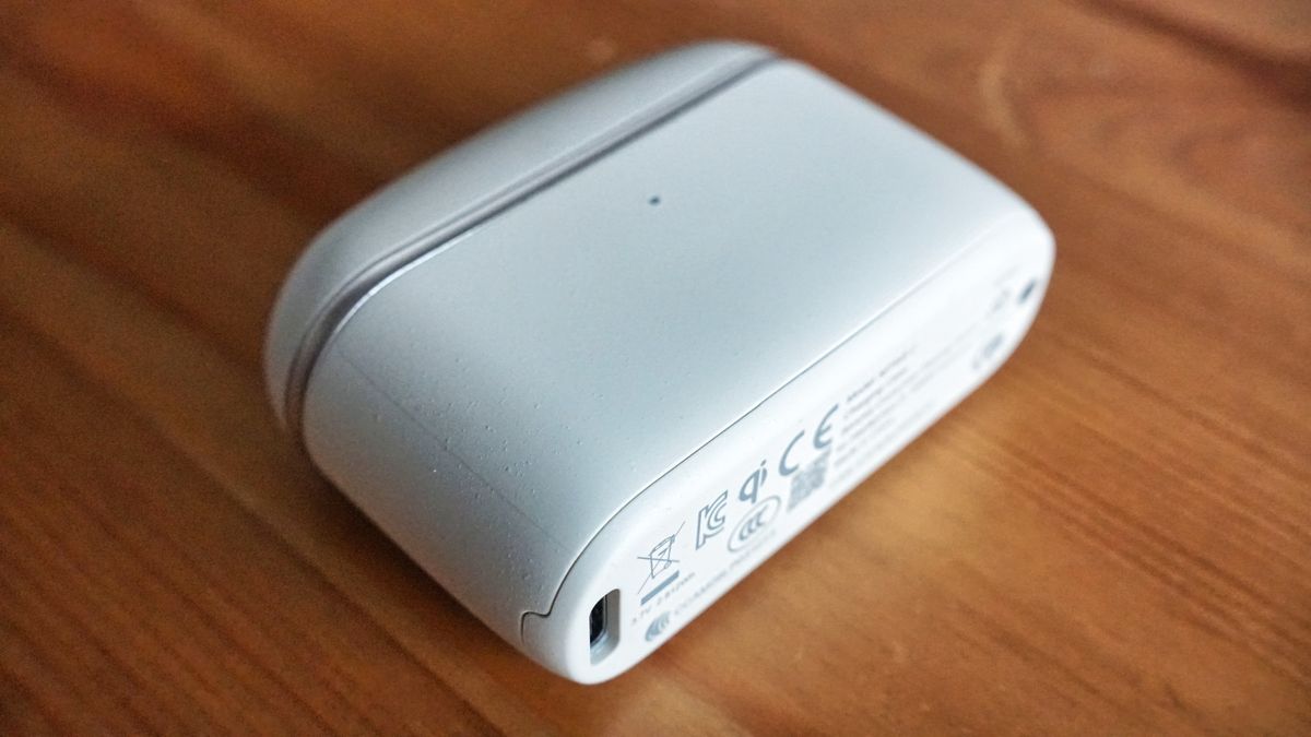 Sennheiser Momentum True Wireless 5 in white, showing details of the buds held in a hand