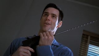Jim Carrey stands smiling, while holding a large cable drill, in The Cable Guy.