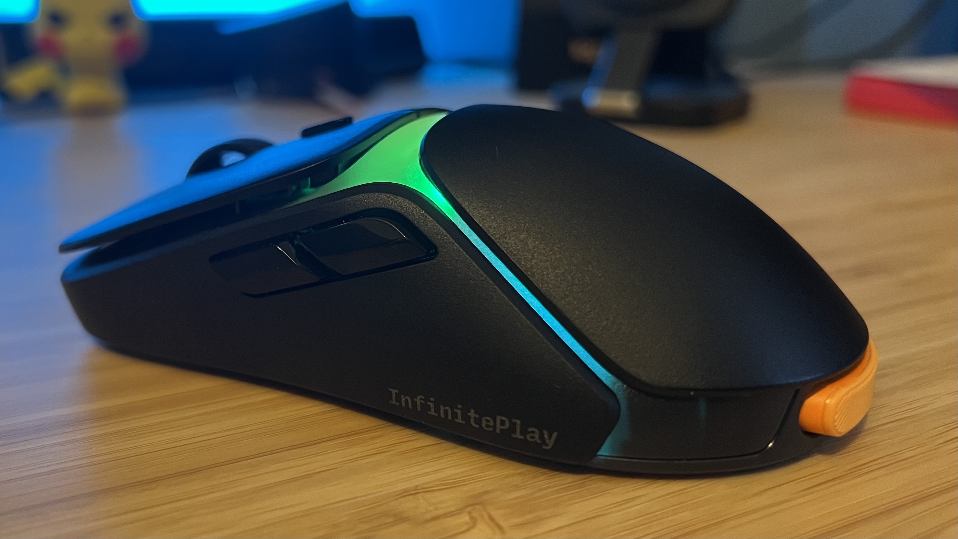 Side view of Glorious Model O 3 Wireless gaming mouse showing buttons on a wooden desk