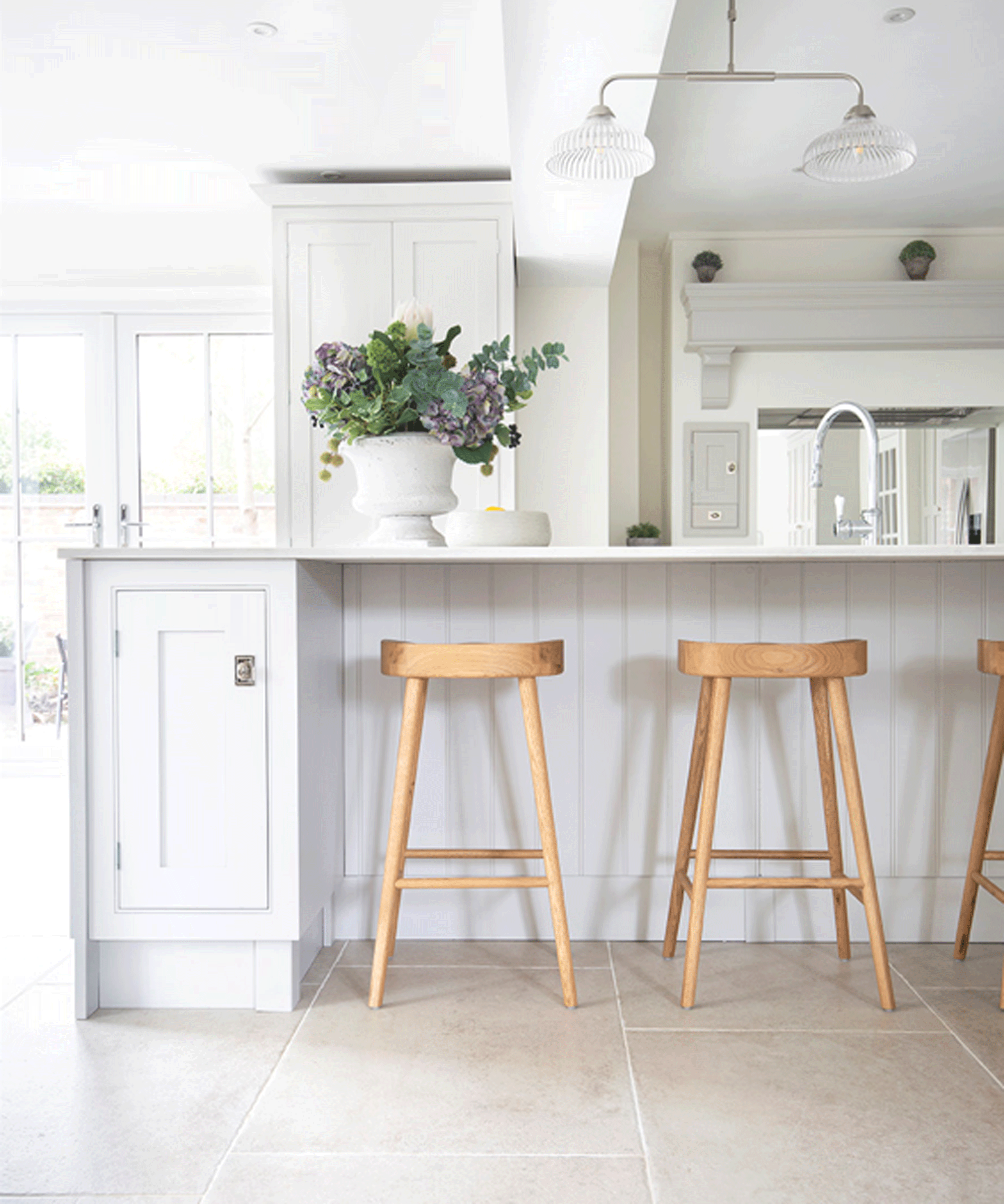 White kitchen island with wooden stools