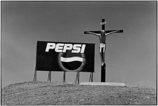 A Pepsi Advertising billboard next to a model of Jesus on the cruciffix