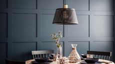 black mesh pendant light in dark grey panelled dining room