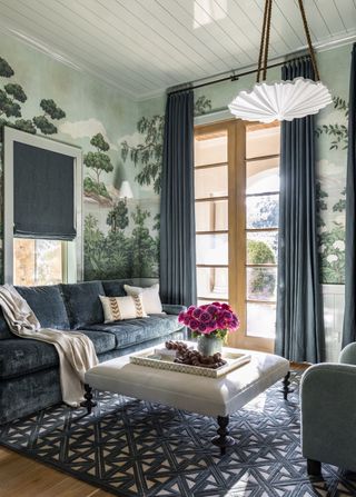 Small living with blue velvet sofas and blue wallpaper