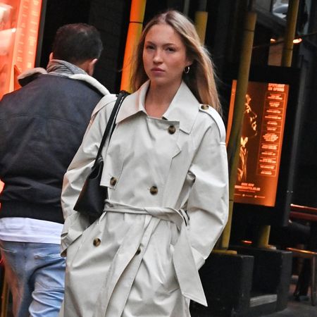 Lila Moss wears a trench coat and jeans.