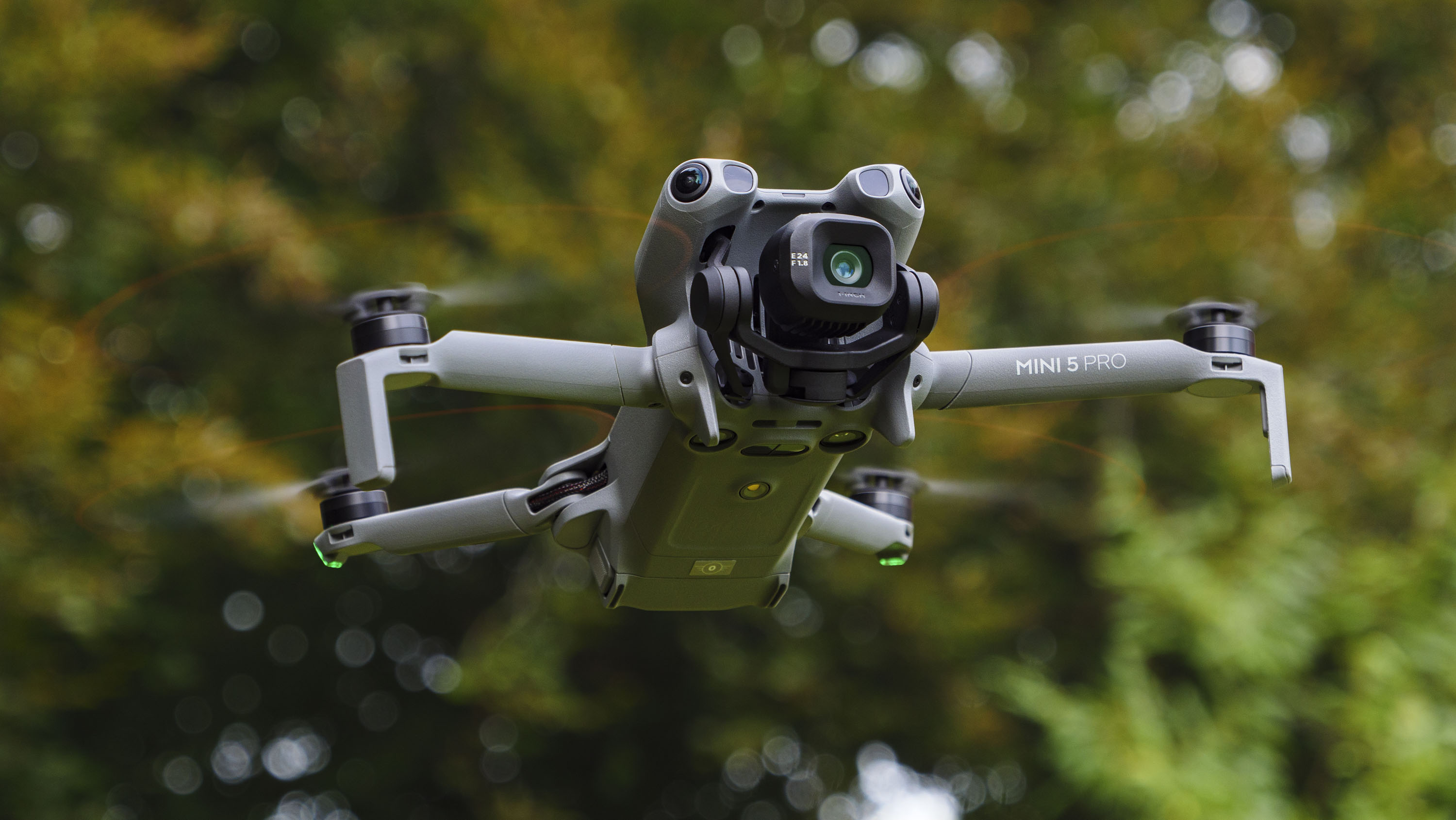 DJI Mini 5 Pro in flight with trees in the background