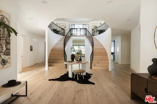 A large entryway with a double curved staircase