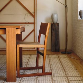 A checkered rug in a neutral dining room