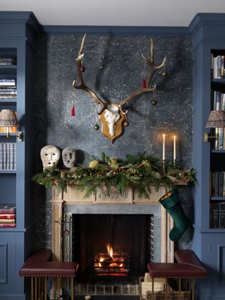 Christmas living room decor with mantelpiece garland and baubles on deer antlers