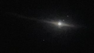 A view of jupiter and its moons in the sky, taken through the telescope