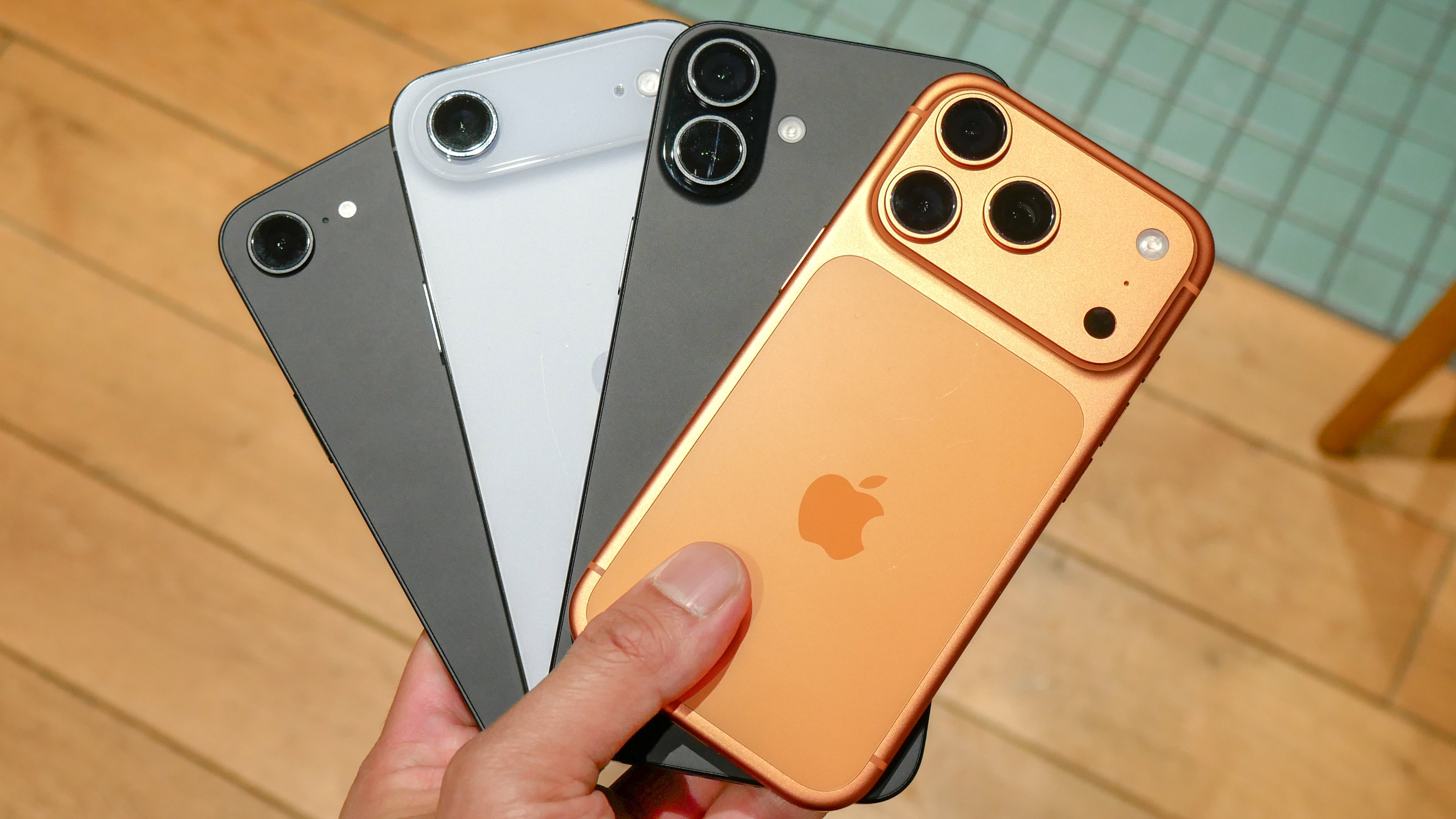 A bunch of iPhones held in the hand.