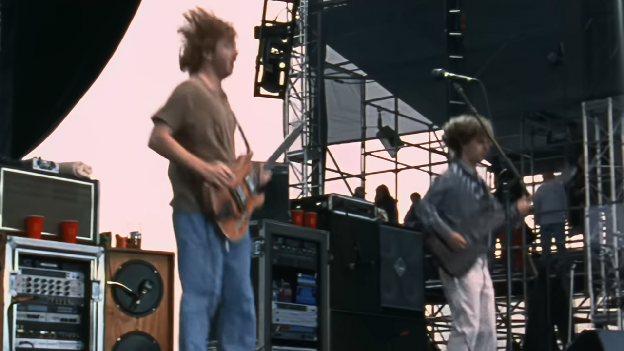 Trey Anastasio and Mike Gordon of Phish jumping on stage and playing guitar
