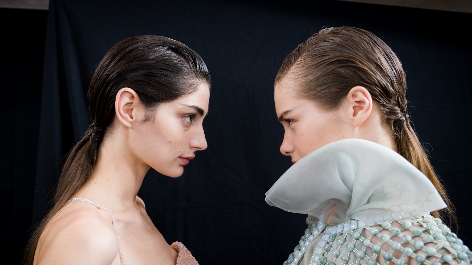 two models facing each other with glowing skin